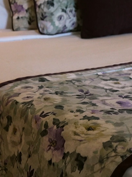 A made bed with a floral runner at the Langdale hotel, Sri Lanka